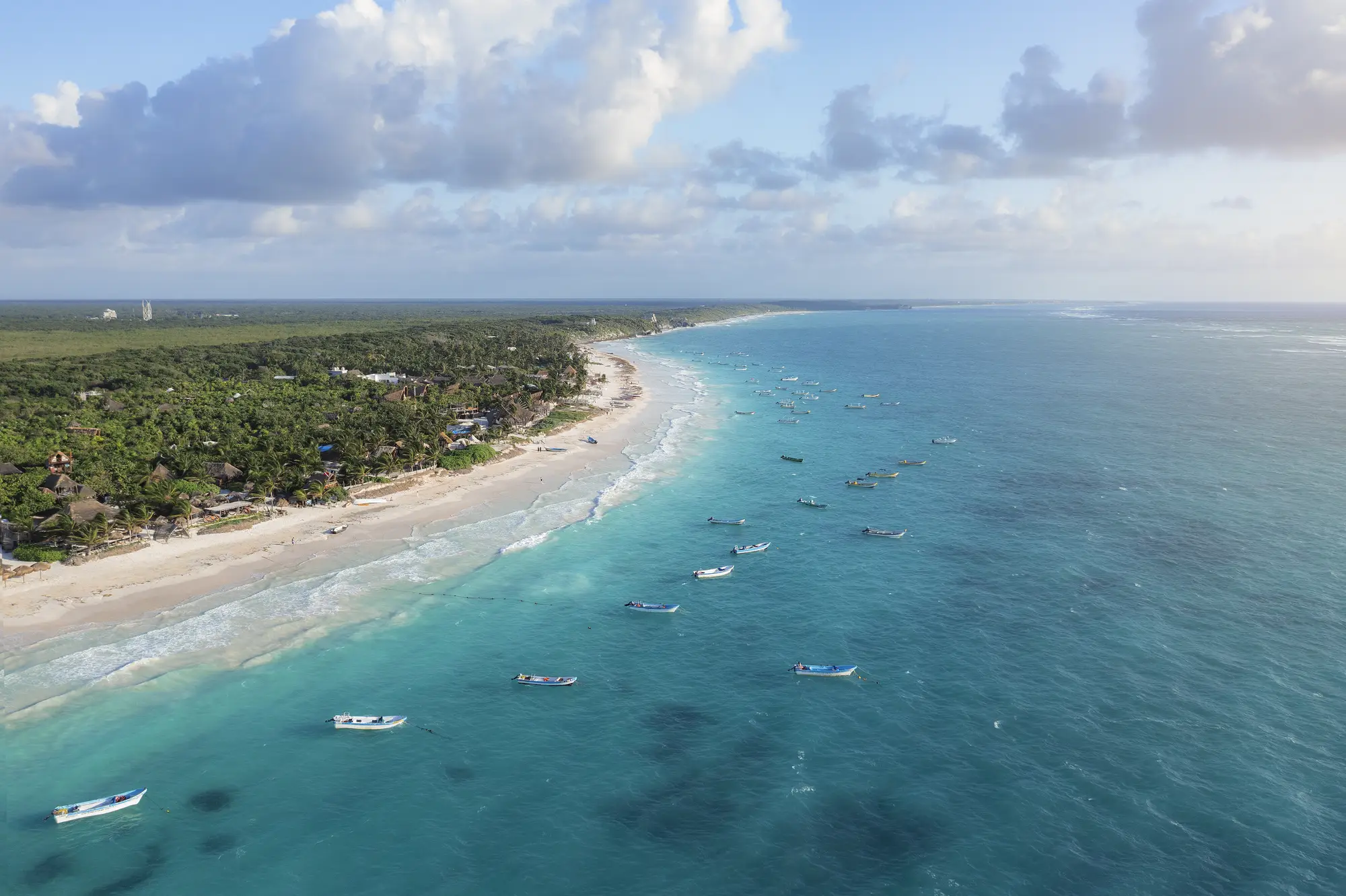 Costa de Tulum con agua turquesa y lanchas