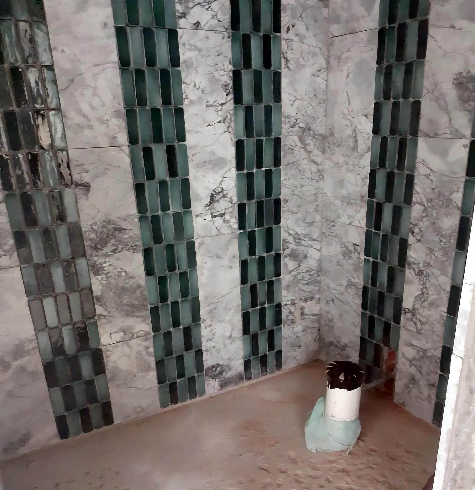 Baño en proceso con mármol y mosaico verde