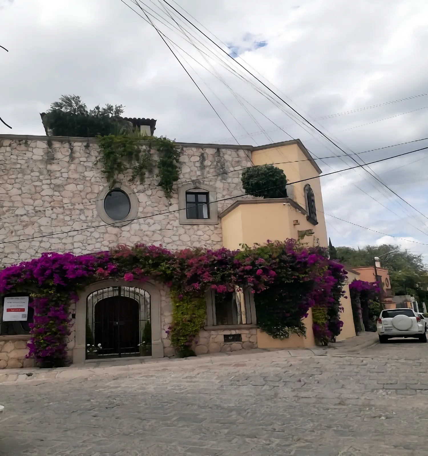 Casa terminada con fachada de piedra y buganvilias