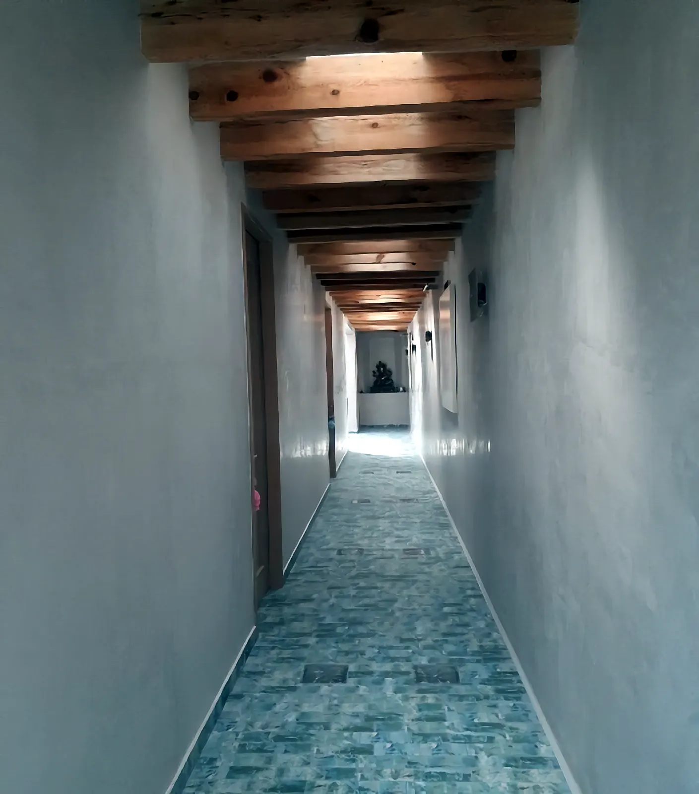 Pasillo con vigas de madera y piso de mosaico